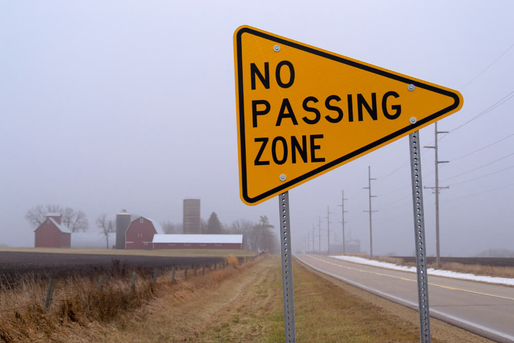 no passing zone sign on a road